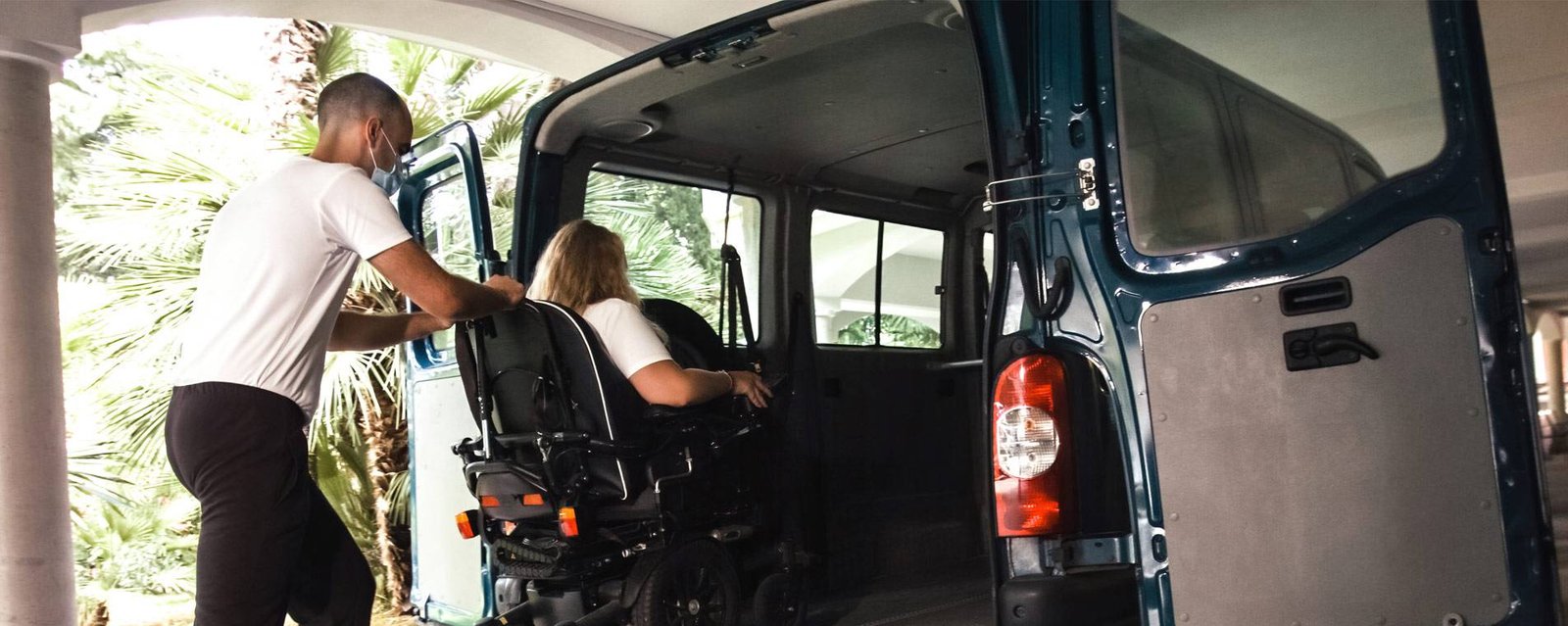 A Trusted Transit driver carefully assisting a passenger into an accessible vehicle